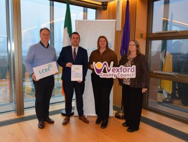 Men and women standing by large windows holding signs