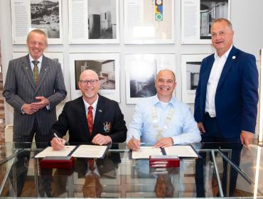 Photograph shows 2 CEO'S and deputy Mayor and John O Rourke signing the sister city agreement