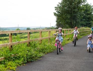 Photo of three children riding bicycles on the greenway
